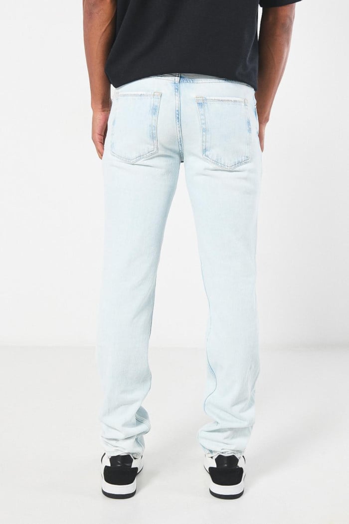 Jean azul claro slim con desgastes, rotos y tiro bajo
